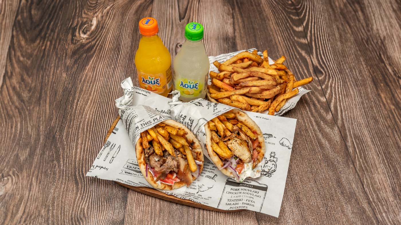 Greek gyros wraps with golden fries served on tray